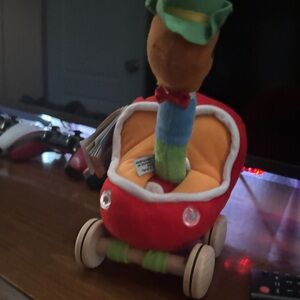 Red Plush Stroller Toy with Orange Interior and Colorful Plush Character
